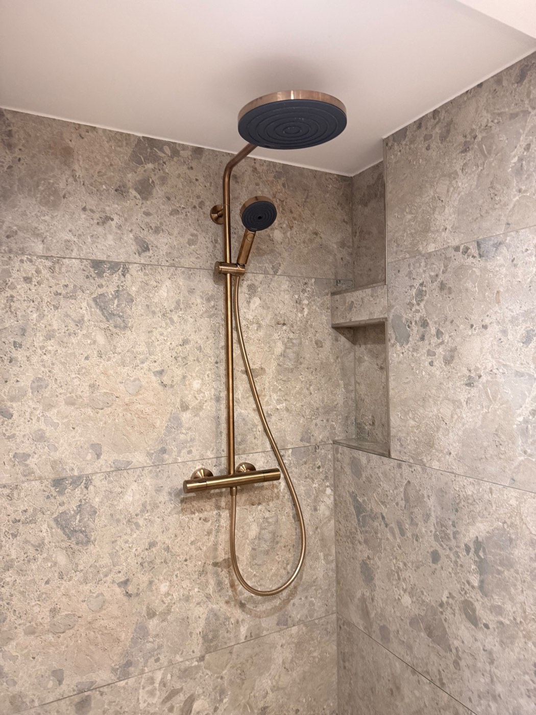 Regendusche in Kupfer-Optik mit Marmorfliesen